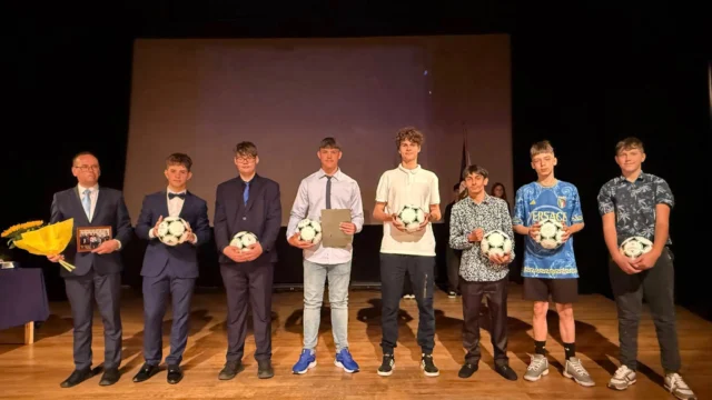 Adidas Tango dla naszych piłkarzy
Zapewne wielu z Was, obecnych na zakończeniu roku szkolnego, zauważyło wyjątkowy moment, kiedy dyrektor naszej Szkoły wręczył specjalny upominek grupie najbardziej zaangażowanych młodych piłkarzy.
Wyróżnieni zostali uczniowie, którzy regularnie – trzy razy w tygodniu – spotykali się wieczorami, by wspólnie grać w piłkę nożną. Wśród nagrodzonych znaleźli się: Szymon F., Marcel, Szymon N., Paweł, Anan z klasy 8a, Dominik z 7a oraz Bartek z 6a.
Pomysł na te wieczorne rozgrywki narodził się podczas wyjazdu Erasmus do Portugalii. To właśnie tam uczniowie zaproponowali, aby po powrocie do Polski kontynuować wspólne granie – tyle że już na naszej szkolnej hali, wieczorową porą. W spotkaniach biorą udział nie tylko uczniowie, ale również absolwenci, rodzice, pracownicy, a nawet – od czasu do czasu – ksiądz proboszcz (choć warto dodać, że aktualnie… brak wolnych miejsc dla nowych chętnych 😉).
Za swoją wytrwałość, zaangażowanie i piękną pasję do sportu nasi piłkarze otrzymali piłkę Adidas Tango – nie byle jaką, bo nawiązującą do legendarnych piłek z Mundiali 1978 i 1982. To właśnie takim modelem grali kiedyś wielcy tego sportu: Mario Kempes, Daniel Passarella, Zbigniew Boniek, Paolo Rossi, Falcão, Zico, Sócrates, Bruno Conti, Michel Platini, Karl-Heinz Rummenigge, Jean Tigana… Dziś ta piłkarska legenda trafia w ręce naszych uczniów – jako symbol ich sportowej drogi.
Kilka słów o samej piłce: Adidas Tango to jeden z najbardziej rozpoznawalnych modeli w historii futbolu. Jej debiut podczas Mistrzostw Świata w 1978 roku zapoczątkował erę nowoczesnego designu futlolówek. Charakterystyczny wzór złożony z 20 trójkątnych grafik – tzw. triad – rozmieszczonych na sześciokątnych panelach tworzył złudzenie 12 wirujących okręgów w ruchu. Ten ponadczasowy design był inspiracją dla piłek aż do początku XXI wieku. Tango wykonana była ze skóry pokrytej powłoką Durlast, co zwiększało jej odporność i wodoodporność i do dziś szyta jest ręcznie (odmiennie, niż większość piłek dostępnych w sklepach, które są szyte maszynowo). Dla wielu piłka Adidas Tango to absolutna klasyka – elegancja, elegancja, technika i historia w jednym!